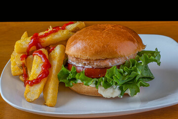 salmon burger on a brioche bun and a side of fries