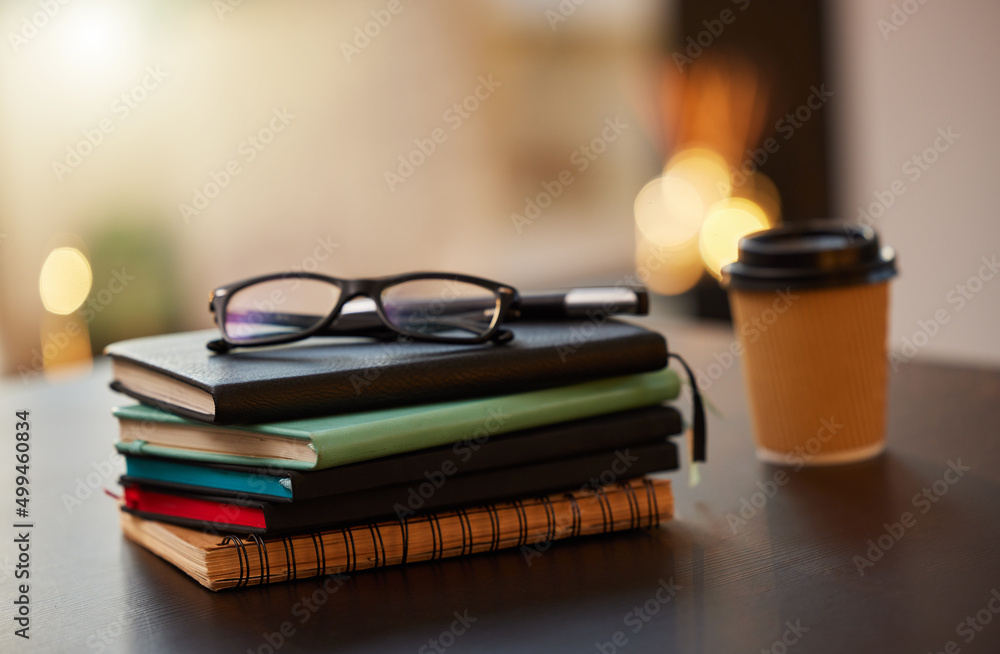 Poster knowledge is power. shot of a stack of books on a table in a office.