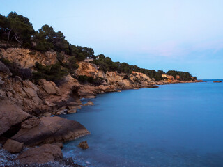 imagen de la playa con las rocas a última hora del día, en una playa de l'Ametlla de Mar