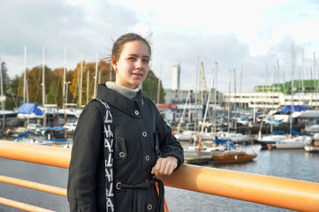 Girl tourist on the background of the yacht club in Tallinn in autumn
