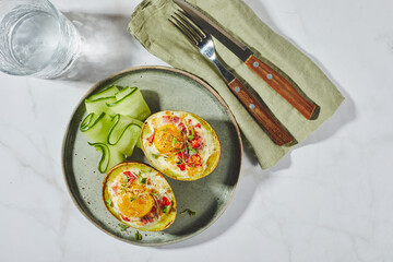 Avocado baked with egg, ham, tomatoes and cheese. Keto lunch recipe. After baking