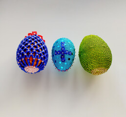 Handmade Easter Eggs made of beads on a white background