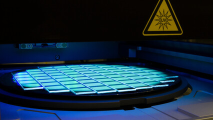 Silicon wafer with chips in UV lighting. Neon. Ultraviolet Lithography.