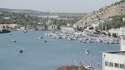 Aerial view of luxury port on a summer day with many yachts. Action. Summer small town with growing...