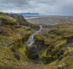 Beautiful autumn view from Mulagljufur Canyon to Fjallsarlon glacier with Breidarlon ice lagoon, Iceland and Atlantic Ocean in far. It is south end of Vatnajokull icecap and Oraefajokull volcano.