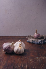 Garlic bulbs on wooden background. Natural antioxidant, anticoagulant, spicy vegetable, healthy diet. Vertical shot, copy space