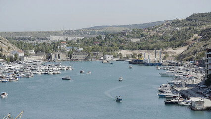 Aerial view of luxury port on a summer day with many yachts. Action. Summer small town with growing...