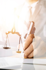 law books and scales of justice on desk in library of law firm. jurisprudence legal education concept.