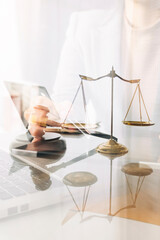 law books and scales of justice on desk in library of law firm. jurisprudence legal education concept.