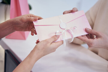 Beauty salon employee giving gift card to client