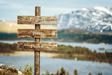 protect your peace text quote written on wooden signpost outdoors in nature with lake and mountain scenery in the background. Moody feeling. - obrazy, fototapety, plakaty