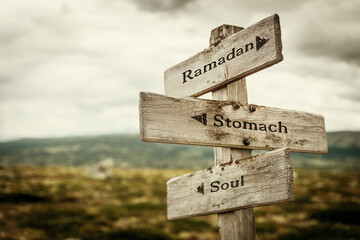ramadan stomach soul text quote written in wooden signpost outdoors in nature. Moody theme feeling.