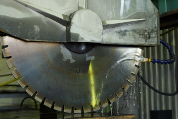 Cutting disc in a stone cutting industrial machine, close-up.