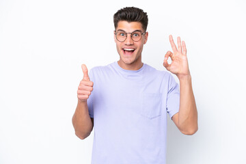 Young caucasian man isolated on white background showing ok sign and thumb up gesture