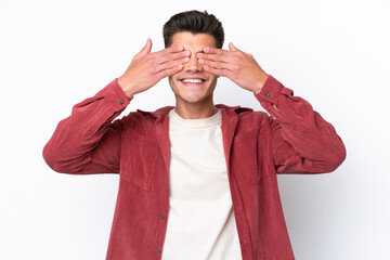 Young caucasian man isolated on white background covering eyes by hands and smiling