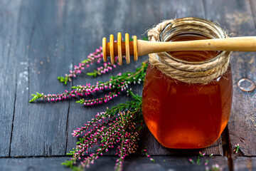 A saucer full of heather honey and a sprig of heather. - obrazy, fototapety, plakaty