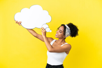 Young african american woman isolated on yellow background holding a thinking speech bubble