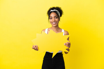 Young african american woman isolated on yellow background holding an empty speech bubble