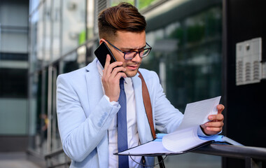 Businessman making a phone call in front of the corporation. Business, education, lifestyle concept