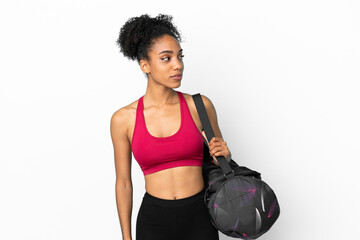 Fototapeta na wymiar Young sport african american woman with sport bag isolated on blue background looking to the side