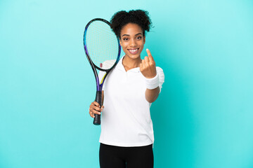 Young tennis player woman isolated on blue background doing coming gesture