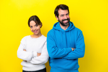 Obraz premium Young caucasian couple isolated on yellow background keeping the arms crossed