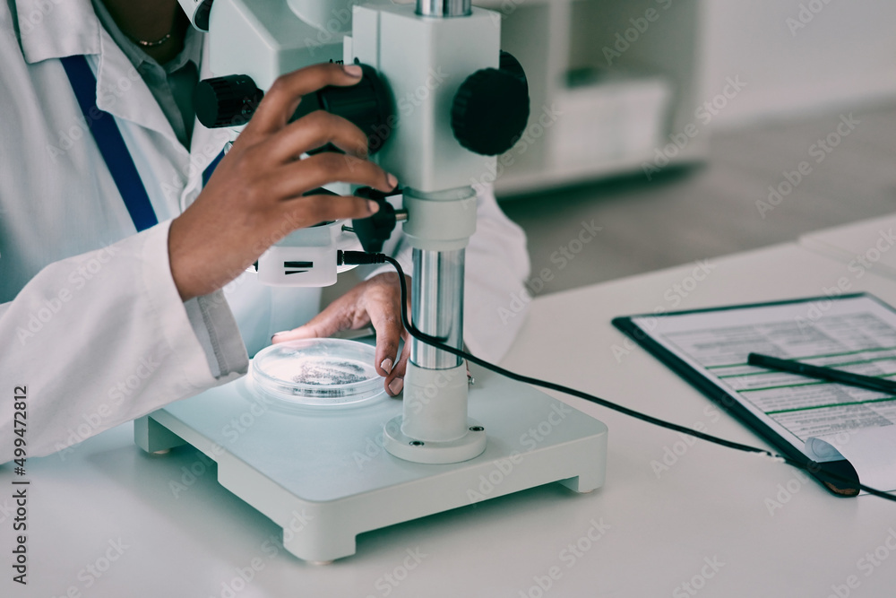 Poster Nothing remains hidden under the microscope light. Cropped shot of an unrecognizable female scientist using a microscope while working in a laboratory.