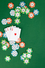 Four aces sit on a pile of poker chips. Copy space is available to the right of the subject. 