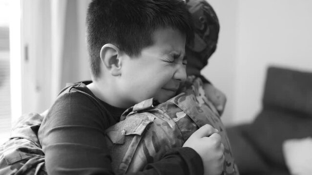 Military soldier father hugging his son after homecoming reunion - Veterans and family love concept - Black and white editing