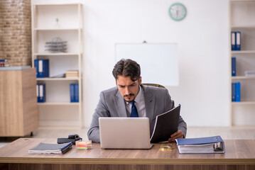 Naklejka premium Young male employee sitting in the office