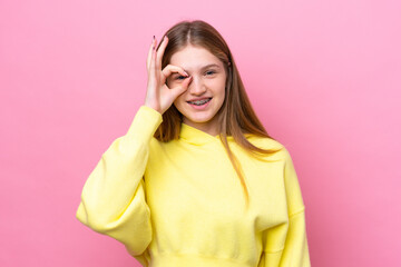 Teenager Russian girl isolated on pink background showing ok sign with fingers