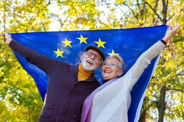 Senior couple holding european union flag outdoors - obrazy, fototapety, plakaty