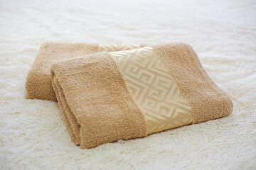 Fototapeta na wymiar Two rolled towels on the bed
