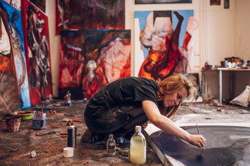 Female painter artist painting and creating her art in a creative studio