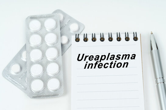 On a white surface are pills in a package, a pen and a notepad with the inscription - Ureaplasma infection