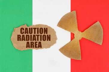 On the flag of Italy, the symbol of radioactivity and torn cardboard with the inscription - caution...