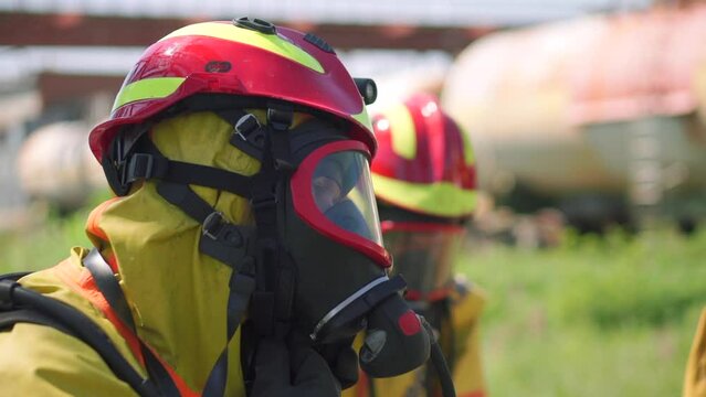 Firefighters. Clip. Two masked men who conduct exercises with a hose and water with special equipment and in a special uniform.