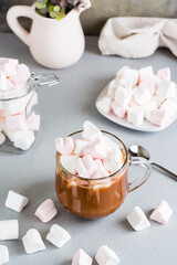 Fototapeta na wymiar Sweet cocoa with heart-shaped marshmallows in a cup and saucer. Vertical view