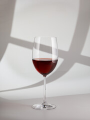 Still life with glass of red wine on white background, copy space