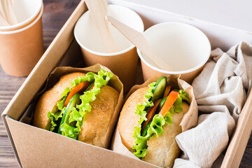 Vegetarian burgers with fresh vegetables and lettuce in a bun in a box. Fast food delivery.