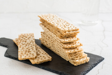 Thin crispy grain bread on slate on the table. Healthy food.