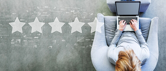 Rating star concept with man using a laptop in a modern gray chair