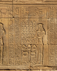 Hieroglyphic carvings on the exterior walls of an ancient egyptian temple