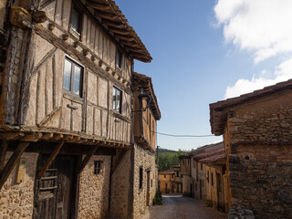 Fototapeta na wymiar Vistas soleadas de casas de arquitectura medieval de madera, en el pueblo de Calatañazor en España, província de Soria, en el verano de 2021