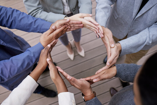 Moving together. Shot of a group of unrecognizable businesspeople forming a circle with their hands outside.
