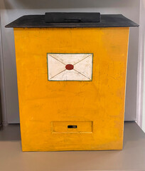 An old yellow metal mailbox.Delivery of letters in ancient times.
