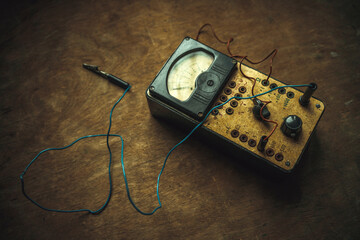 Vintage current measuring device. Voltmeter on a wooden table in retro style.