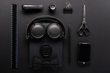 Image of a robot made of office supplies. Listen to music. Headphones and smartphone. Flat lay.