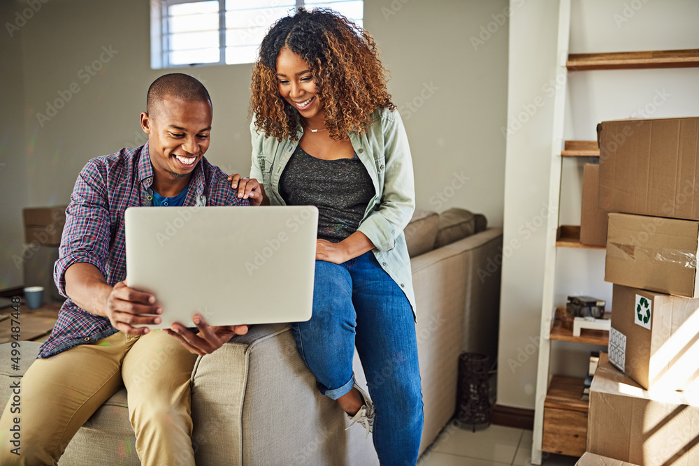 Poster What do you think of this color for the walls. Shot of a cheerful young couple doing online shopping together while being seated on a couch at home.