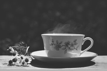 Taza de té caliente con manzanilla en blanco y negro